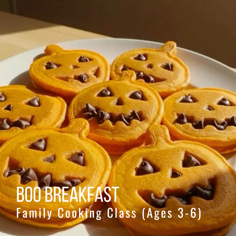 Plate of pumpkin-shaped pancakes with chocolate chip smiles.