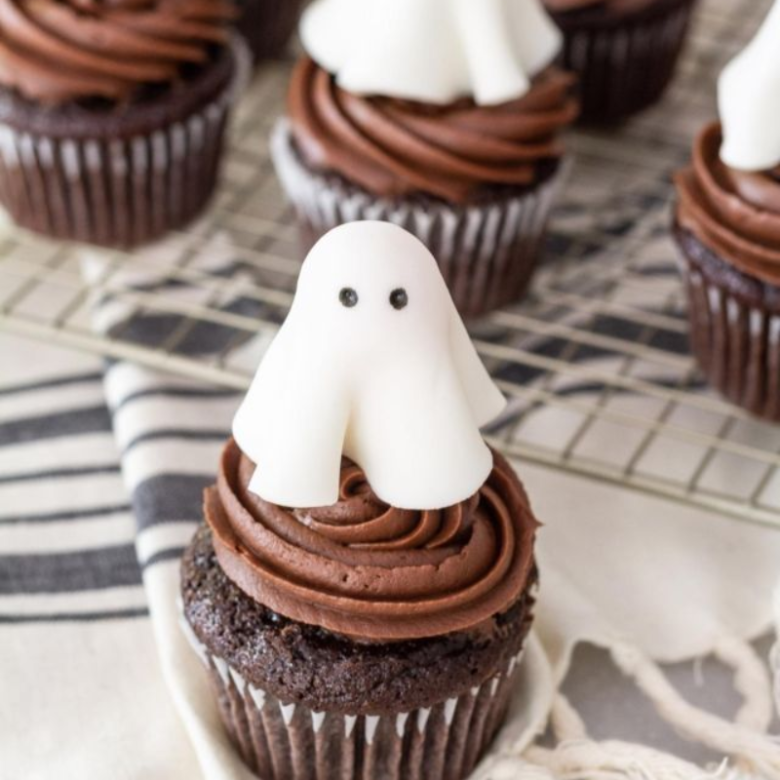 Chocolate cupcake topped with a white ghost marshmallow.