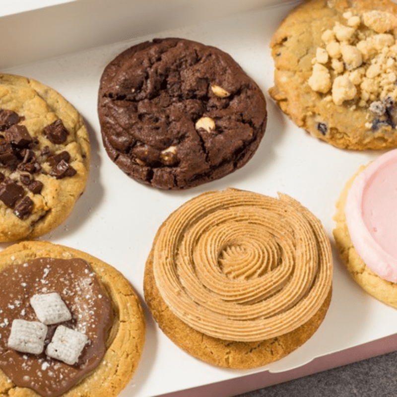 Assorted cookies with various toppings and frostings in a box.