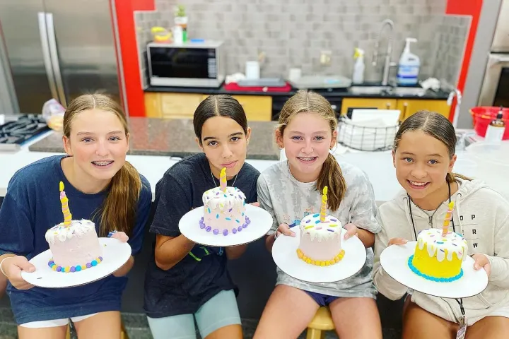 Melissa Mars et al. sitting at a table with a birthday cake