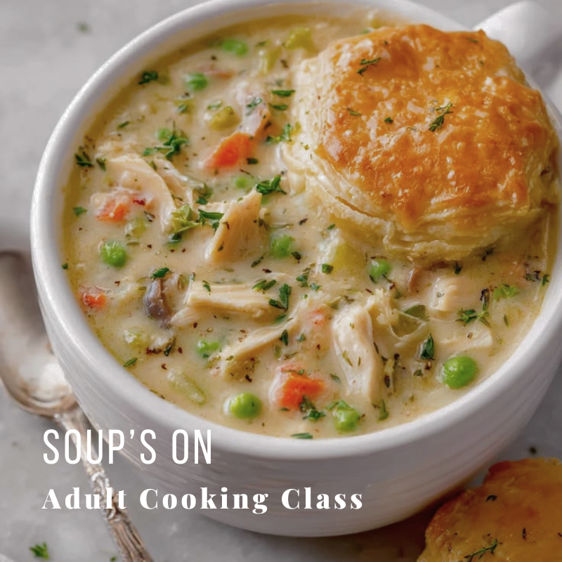 Hearty soup with vegetables and pastry in a white bowl on a table.