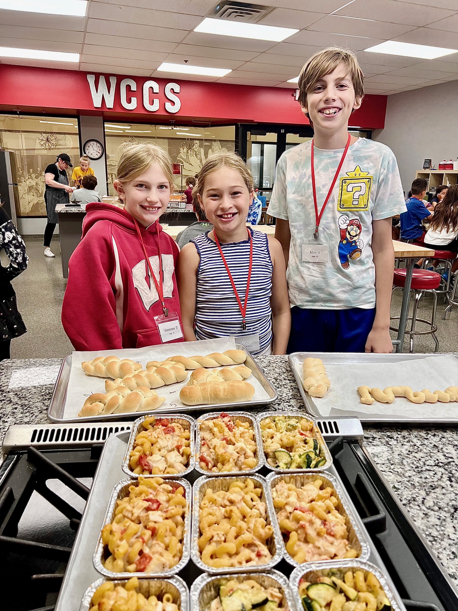 a group of people standing in front of a tray of food