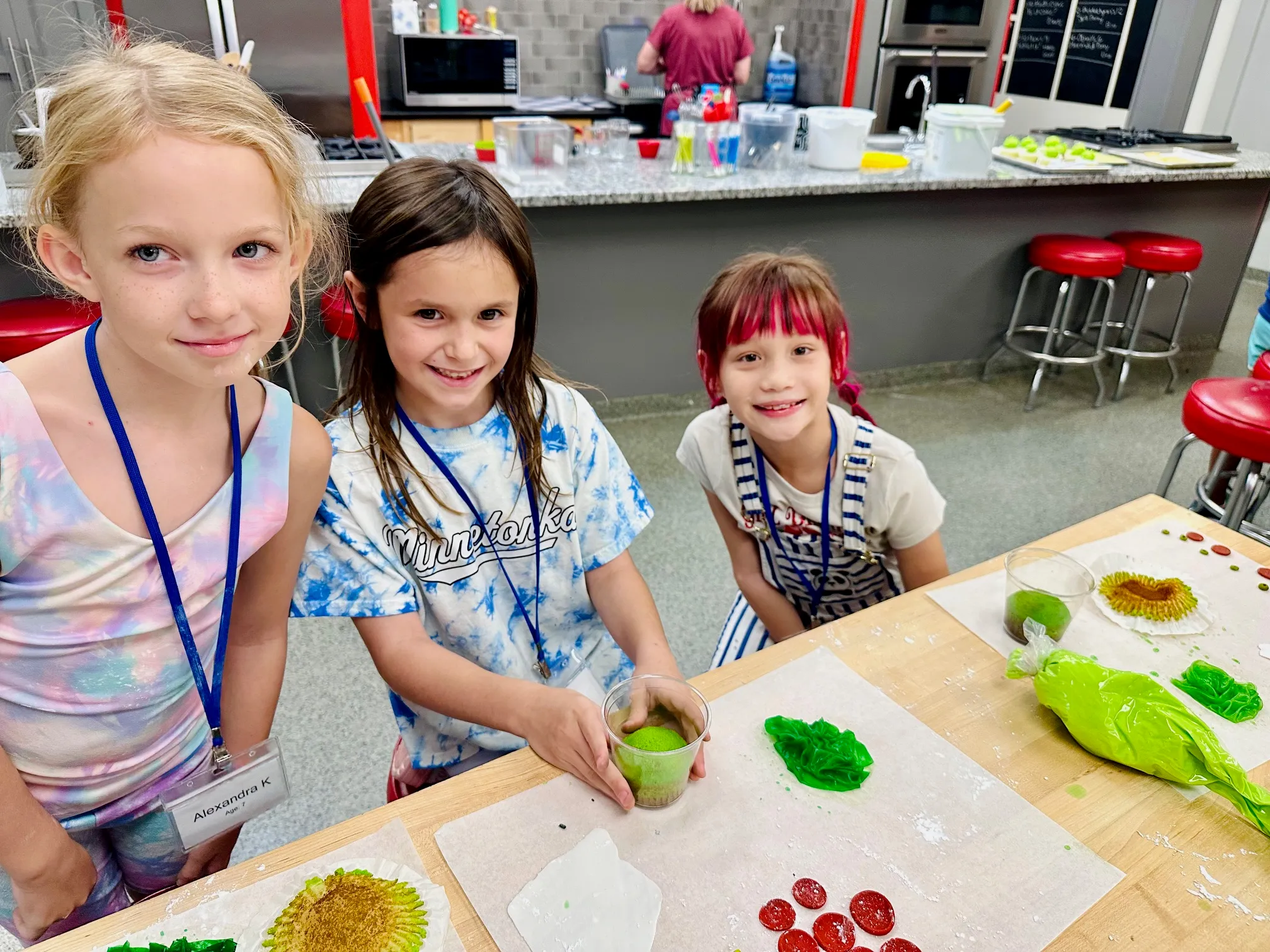 a little girl sitting at a table in front of a cake