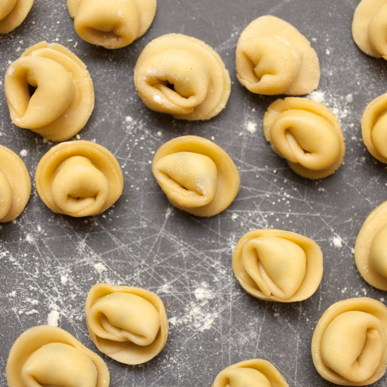 a tray of hot dogs cooking on a grill