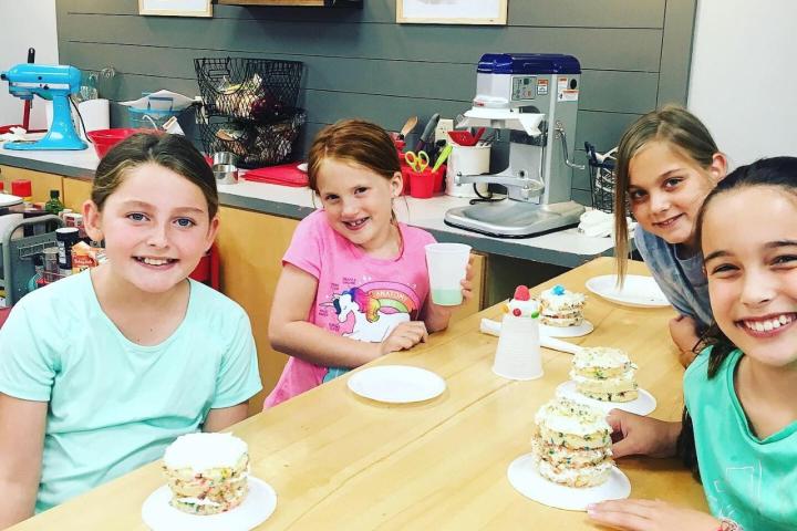 Rosie McClelland et al. sitting at a table with a birthday cake