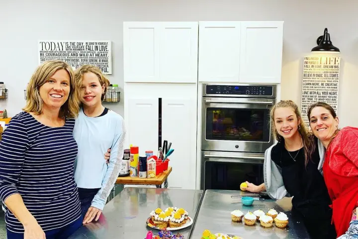 Kristen Gast et al. sitting at a table with a plate of food