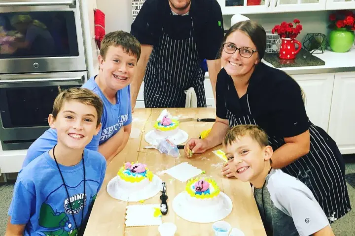Bryce Robinson et al. sitting at a table with a birthday cake