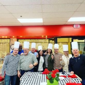 a group of people standing around a table