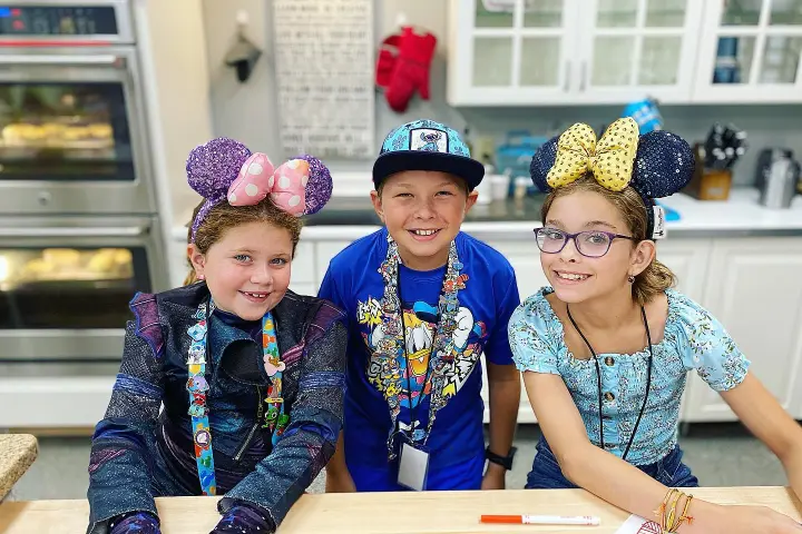 a group of people sitting at a table with a birthday cake