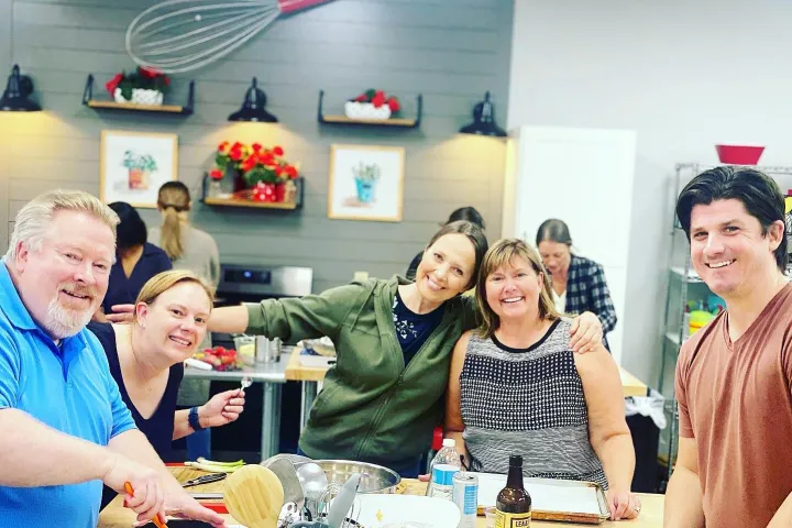 a group of people standing around a table
