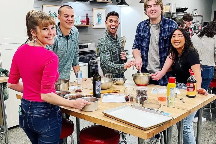 a group of people standing around a table