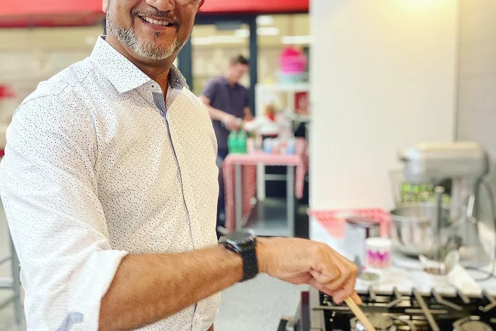 a man standing in front of a pizza