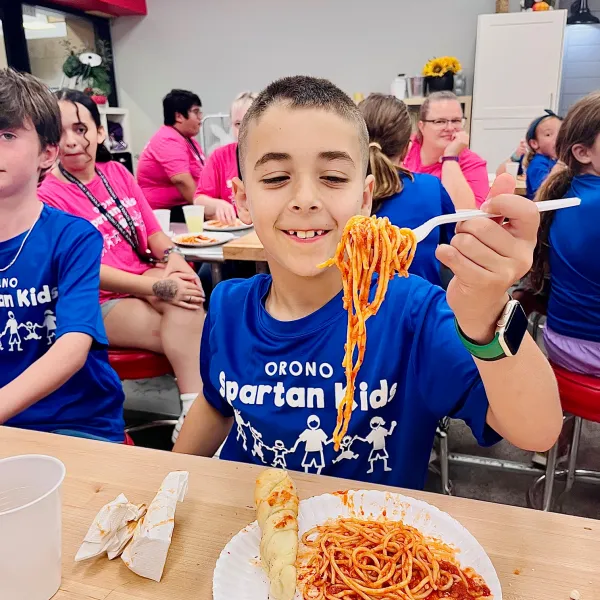 a group of people sitting at a table eating pizza