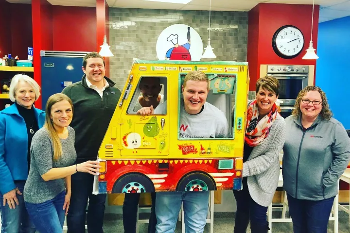 a person standing in front of a group of people posing for the camera