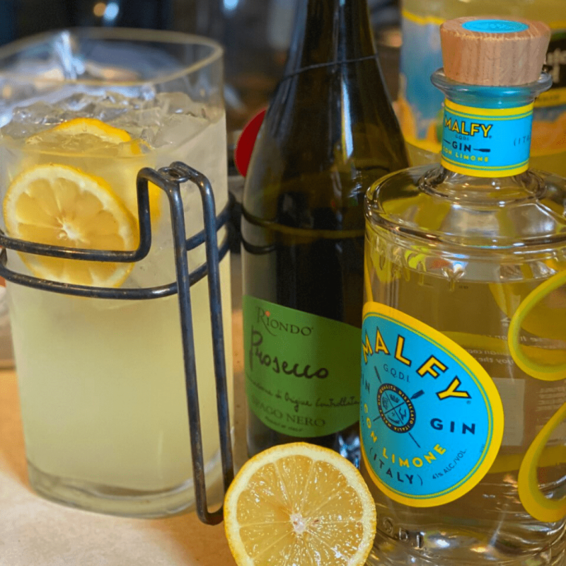 a close up of a bottle and a glass of orange juice