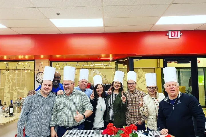 a group of people standing around a table