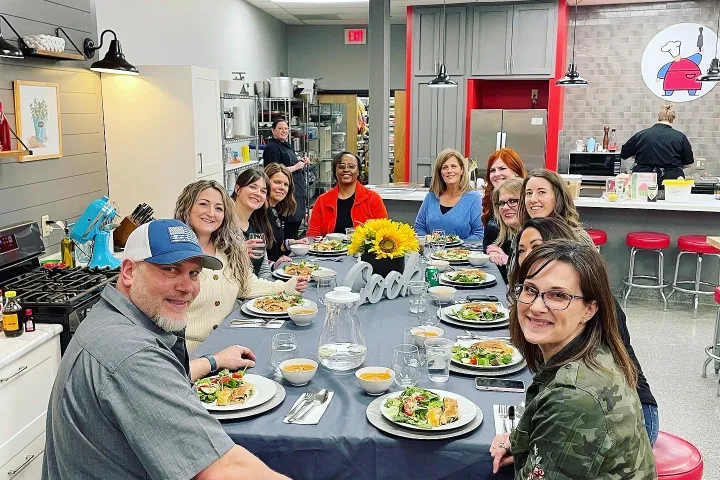 a group of people sitting at a table with food