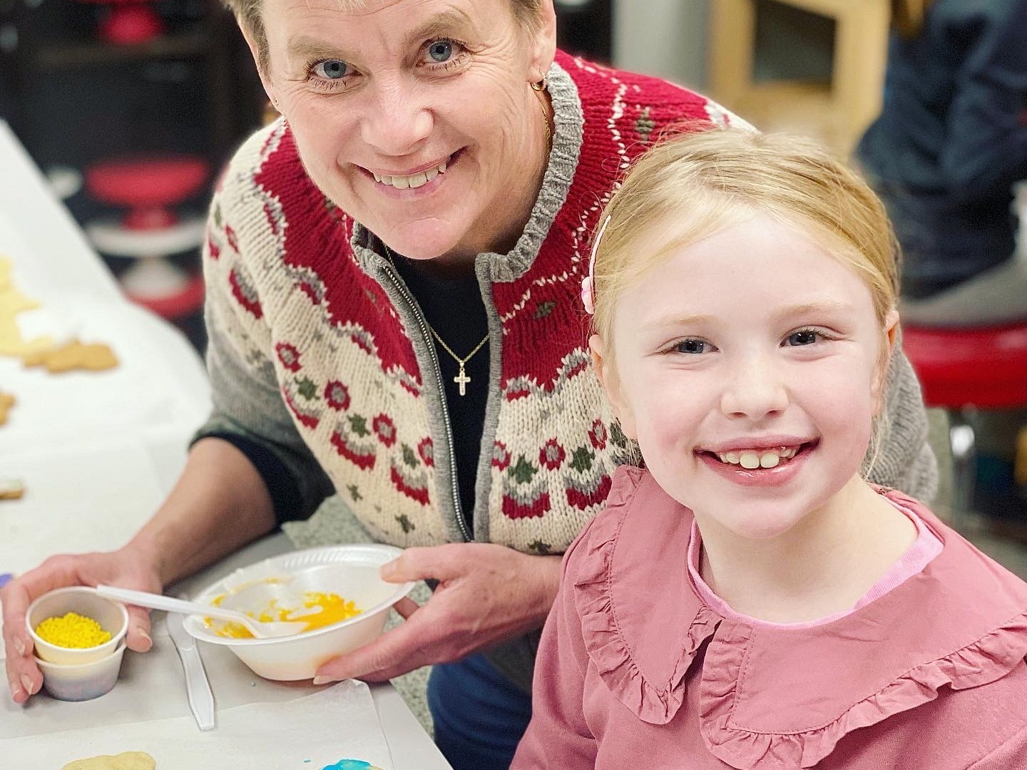 a little girl sitting at a table eating food