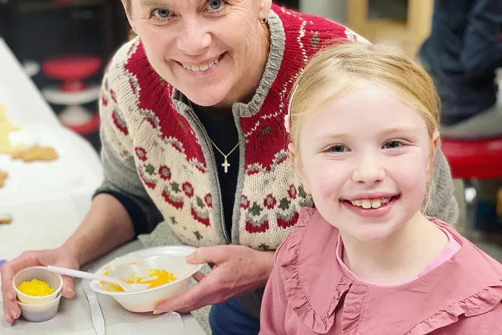 a little girl sitting at a table eating food
