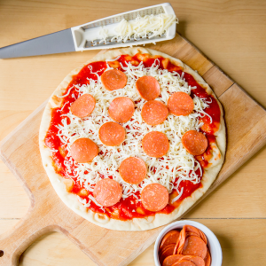 a pizza sitting on top of a wooden cutting board