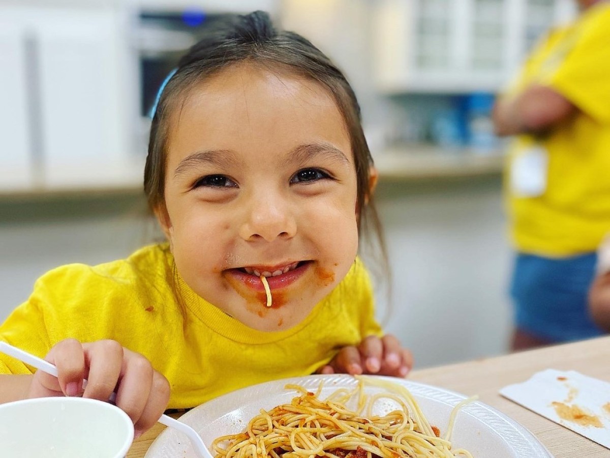 a person sitting at a table eating food