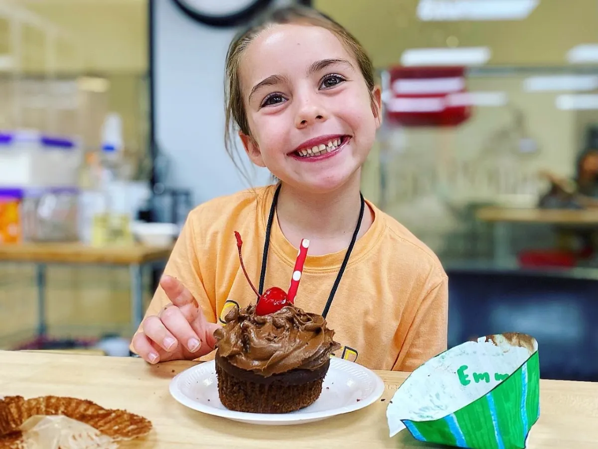 a woman sitting at a table with a cake on a plate