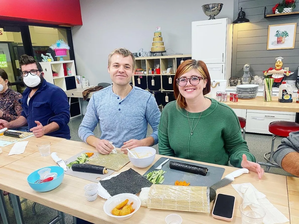 a group of people sitting at a table with a cake