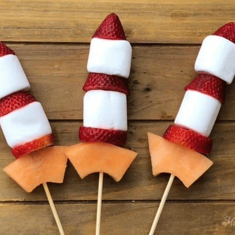 Fruit skewers with strawberries, marshmallows, and melon slice on sticks.