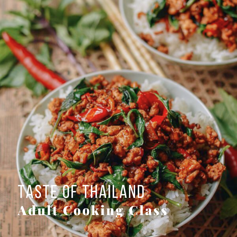 Bowl of Thai basil chicken with rice, garnished with chili and herbs.